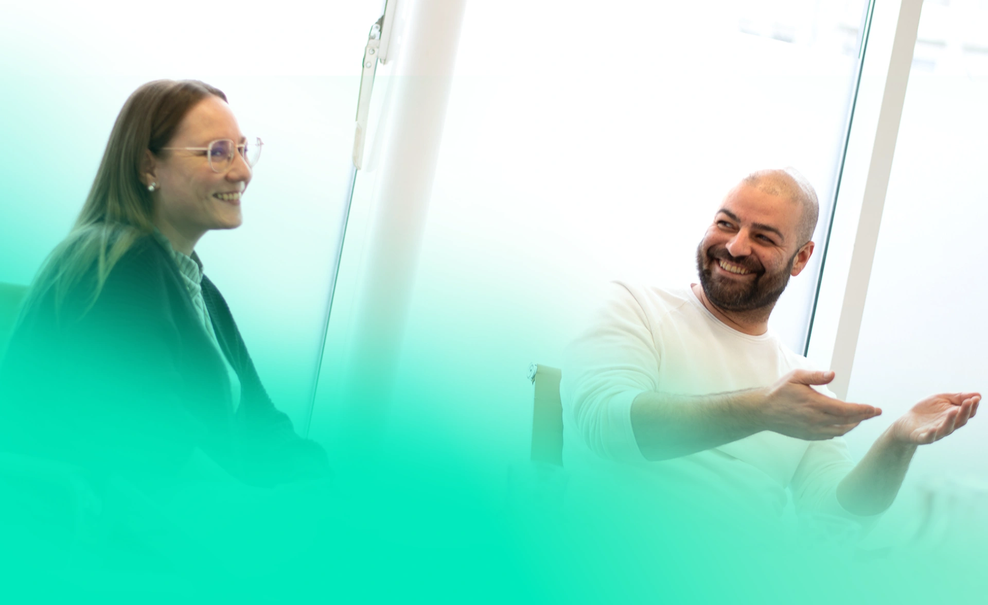 Teammitglieder Ayline und Sven bei einer Besprechung in ausgelassener Stimmung